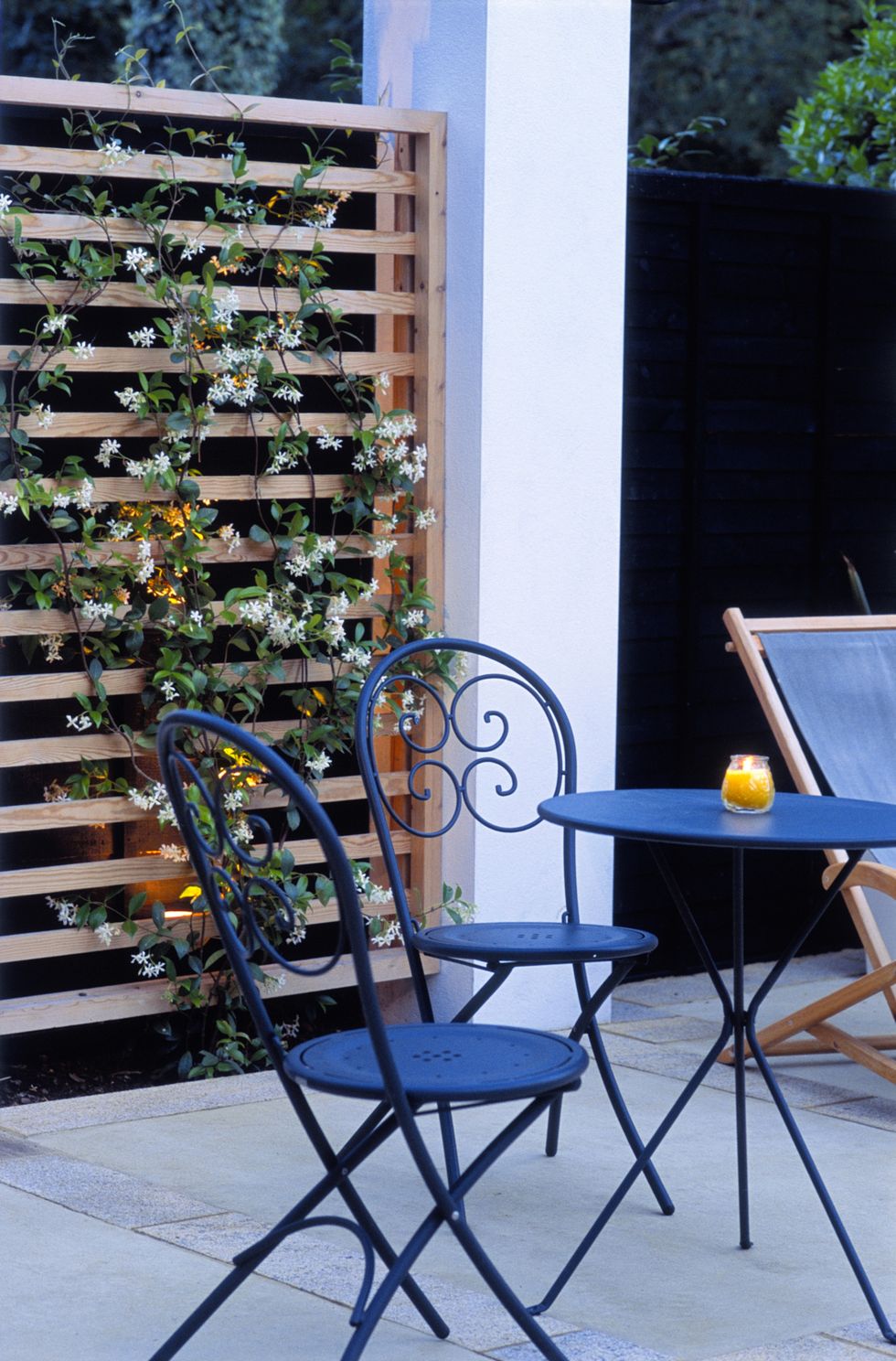 Patio with outdoor furniture with climbing Trachelospermum jasminoides (Star Jasmine)