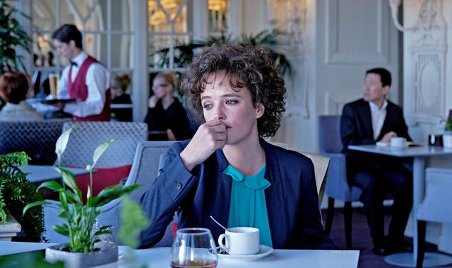 susana abaitua con mirada perdida, en una cafetería, caracterizada como nerea en la serie 'patria' de hbo