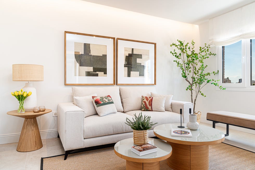 sofá beige con mesas nido redondas de madera