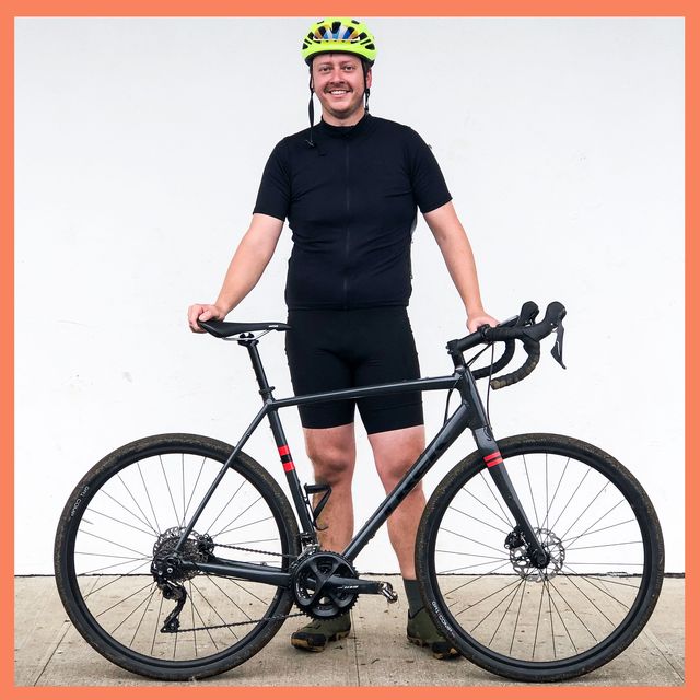 Patrick Daly posing with his bike in cycling gear.