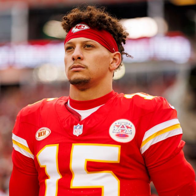 patrick mahomes gazes into the distance, he wears a red football uniform with the number 15 on his jersey and a red kansas city chiefs headband
