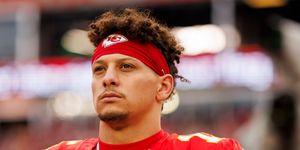 patrick mahomes gazes into the distance, he wears a red football uniform with the number 15 on his jersey and a red kansas city chiefs headband