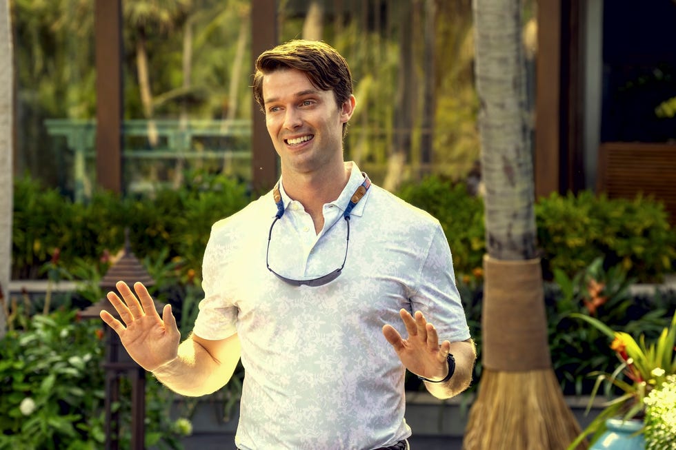 individual gesturing while surrounded by greenery