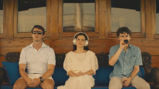 group of three individuals seated on a couch