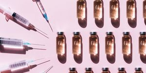 pattern made with set of clean syringes placed near vial of liquid drug near copy space on pink background with shadows and light reflections flat lay style