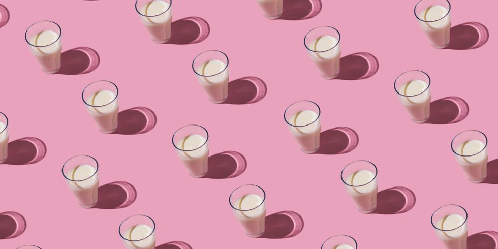 pattern of glass cups filled with milk in hard light on pink background dairy, shortage, calcium, grow and drink concept