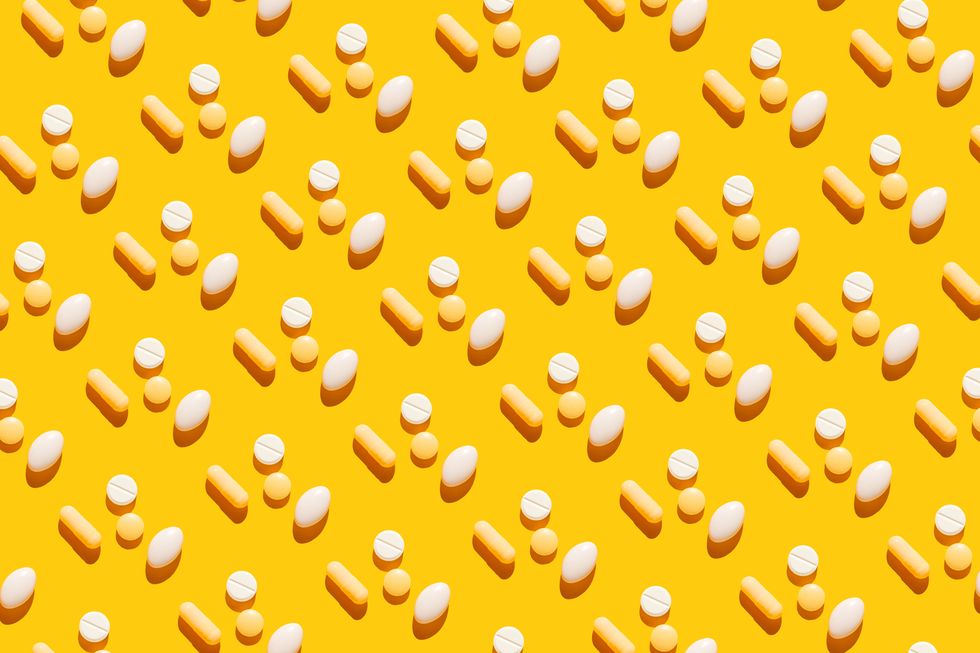 pattern of pills on yellow background taking tablets, capsules, vitamins, painkillers, medications and dietary supplements minimal medical, health care, pharmacology concept flat lay, top view