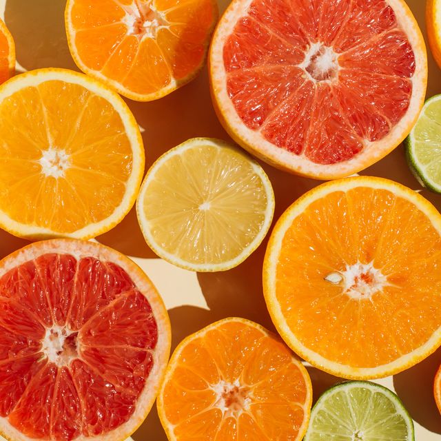 pattern of slices citrus fruit of lemons, oranges, grapefruit, lime on beige background. healthy food, diet and detox concept. flat lay, top view