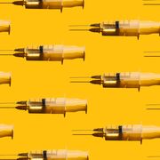 pattern of syringes with a vaccine on yellow background concept of medical treatment or vaccination