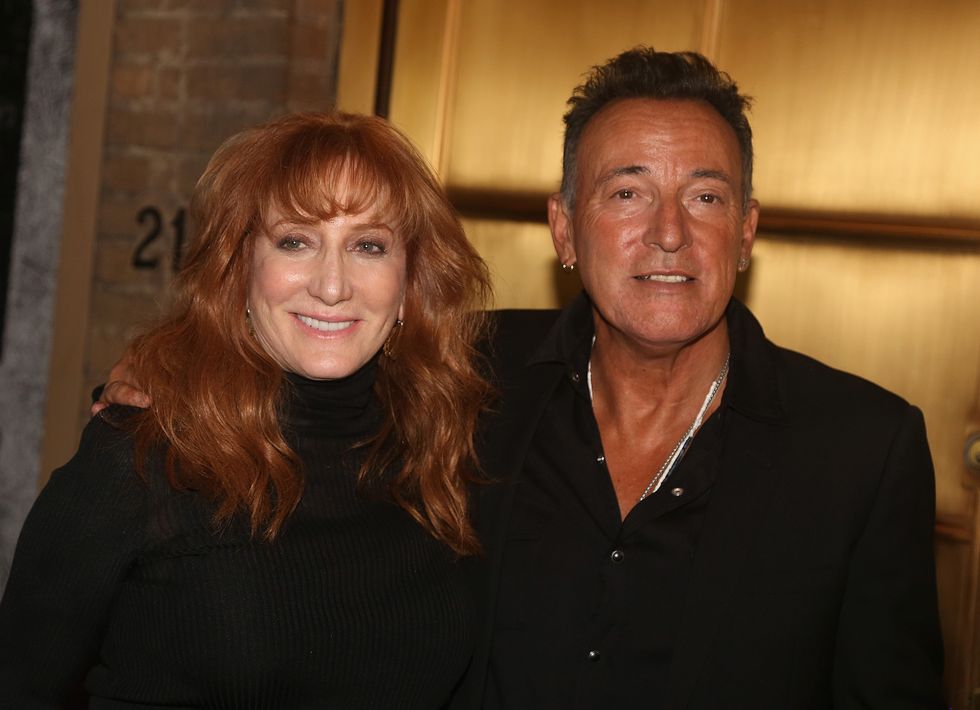 bruce springsteen embracing wife patti scialfa with his right arm with the two smiling for a photo