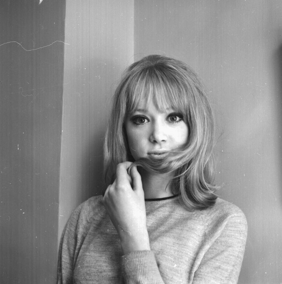 foto della modella e attrice pattie boyd mentre si tiene i capelli tra le dita e in bocca