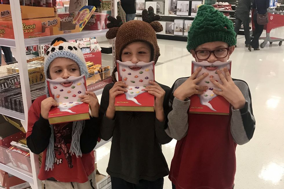 the writer's three sons trying on santa beards in target