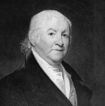 black and white portrait of an older man shown wearing a dark coat and a light collared shirt
