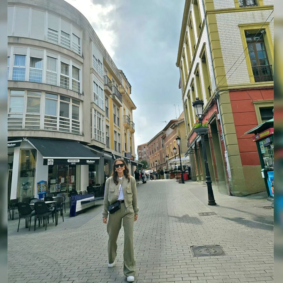 a person standing on a street between buildings
