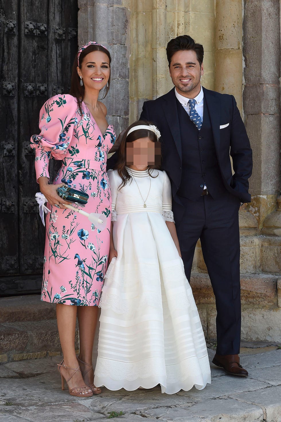 la actriz y el cantante con su hija vestida de comunión
