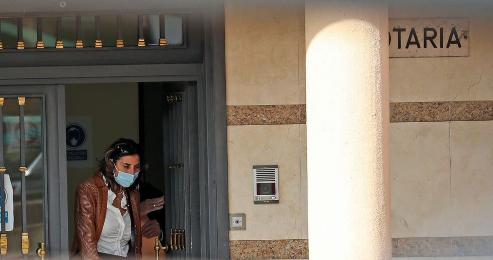 la presentadora sale del portal de un edificio que acoge una notaría