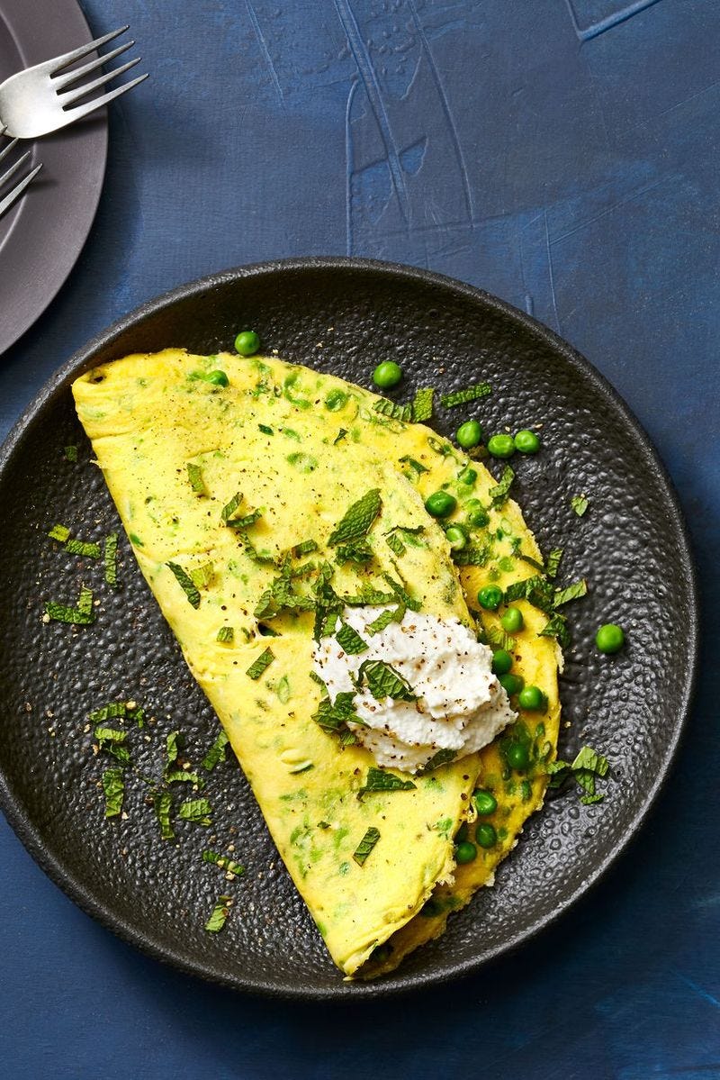 pea and ricotta omelets on a black plate