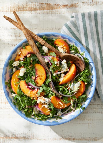 a bowl of peach, arugula, and blue cheese salad