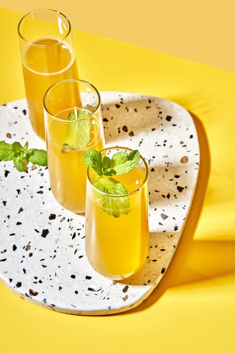 yellow peach bellinis on a white marble speckled tray on a yellow background