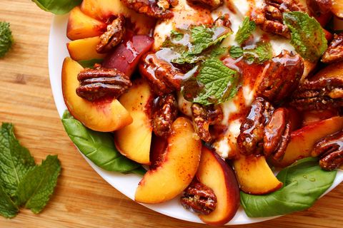 peach burrata basil salad topped with hot honey, candied pecans, and mint