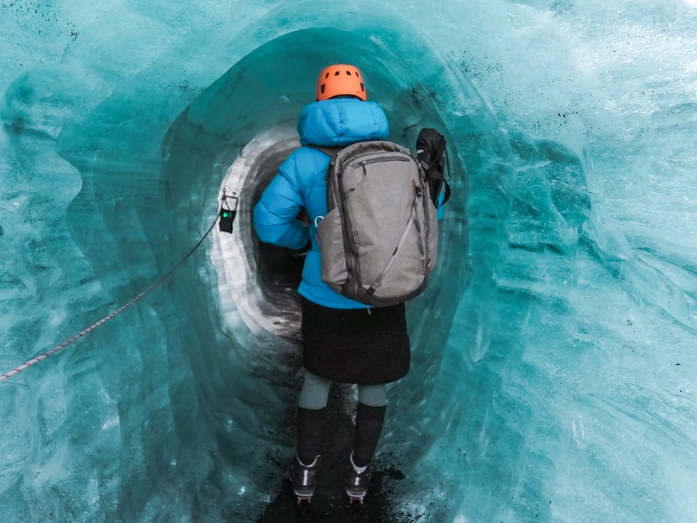 a person wearing a backpack and standing in an ice cave