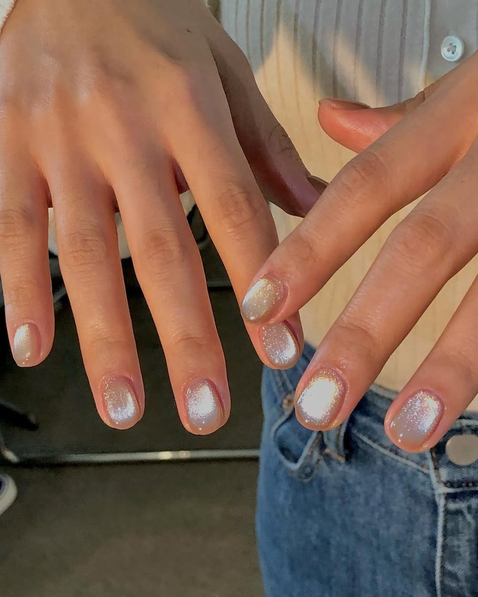 closeup of hands showcasing manicured nails with a sparkly finish