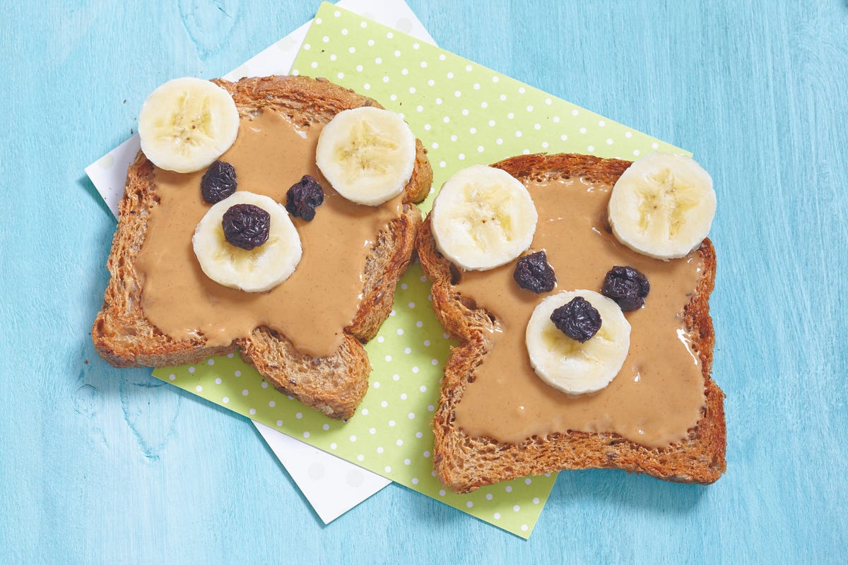 bread with peanut butter, bananas, raisins in the shape of a bear face