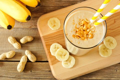peanut butter banana oat smoothie with straws, on wood
