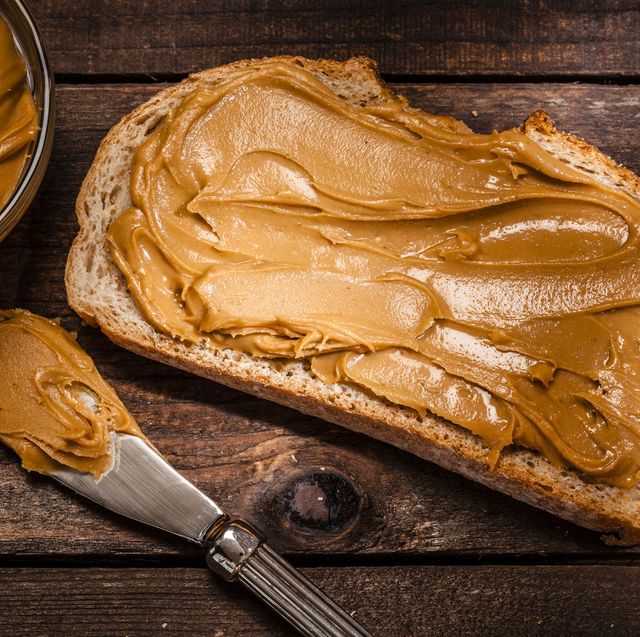 peanut butter on bread slice shot on rustic wooden table