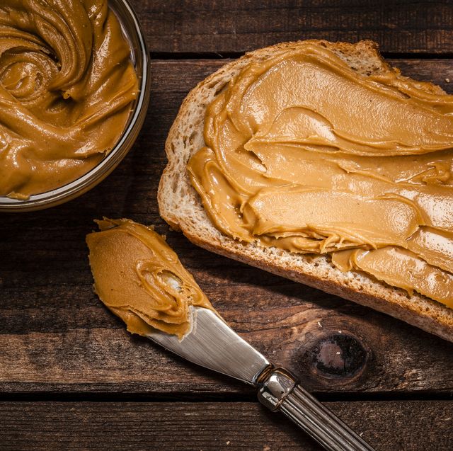 peanut butter on bread slice shot on rustic wooden table