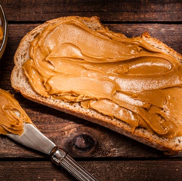 Peanut butter on bread slice shot on rustic wooden table peanut butter on bread slice shot on rustic wooden table