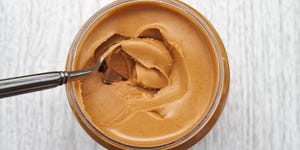 Peanut butter on spoon in jar