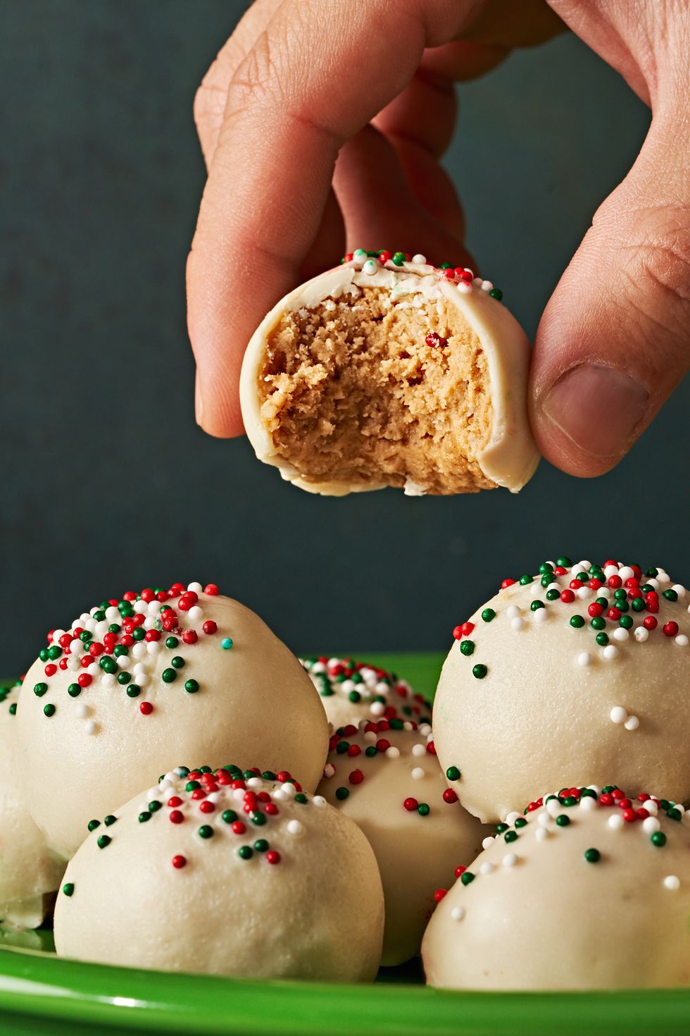 peanut butter truffles covered in white chocolate and red green and white nonpareil sprinkles