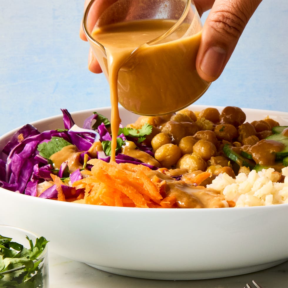 peanut chickpea protein bowls with rice, crispy chickpeas, red cabbage, carrot, cucumbers, and peanut sauce