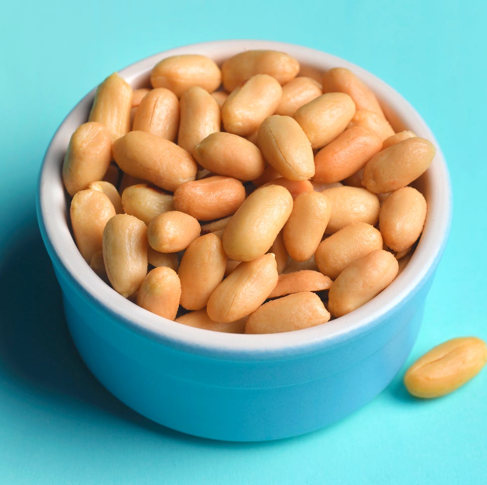 peanuts in a blue bowl on blue background peanuts in a blue bowl on blue background