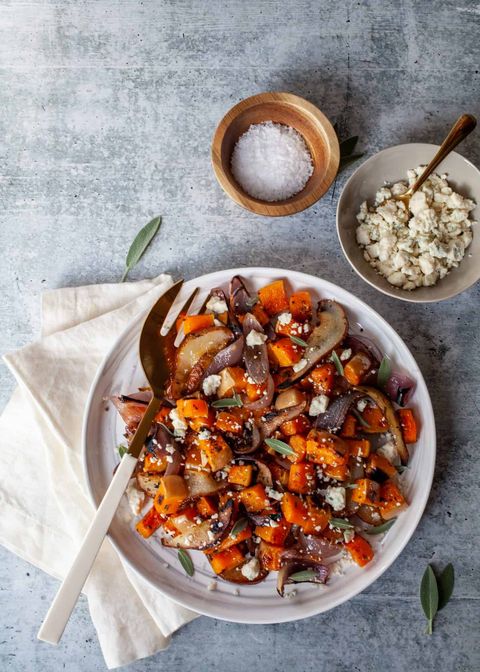 roasted butternut squash red onions and pears on white plate with serving fork