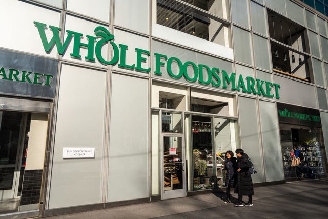 Pedestrians walk past an american multinational supermarket...