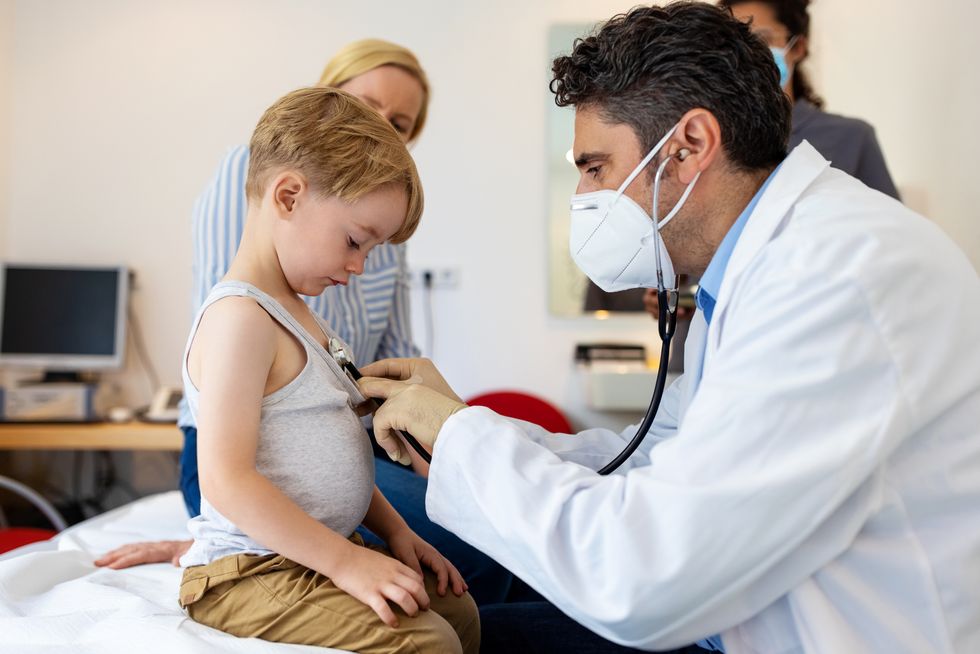 pediatra observando los síntomas de un niño enfermo