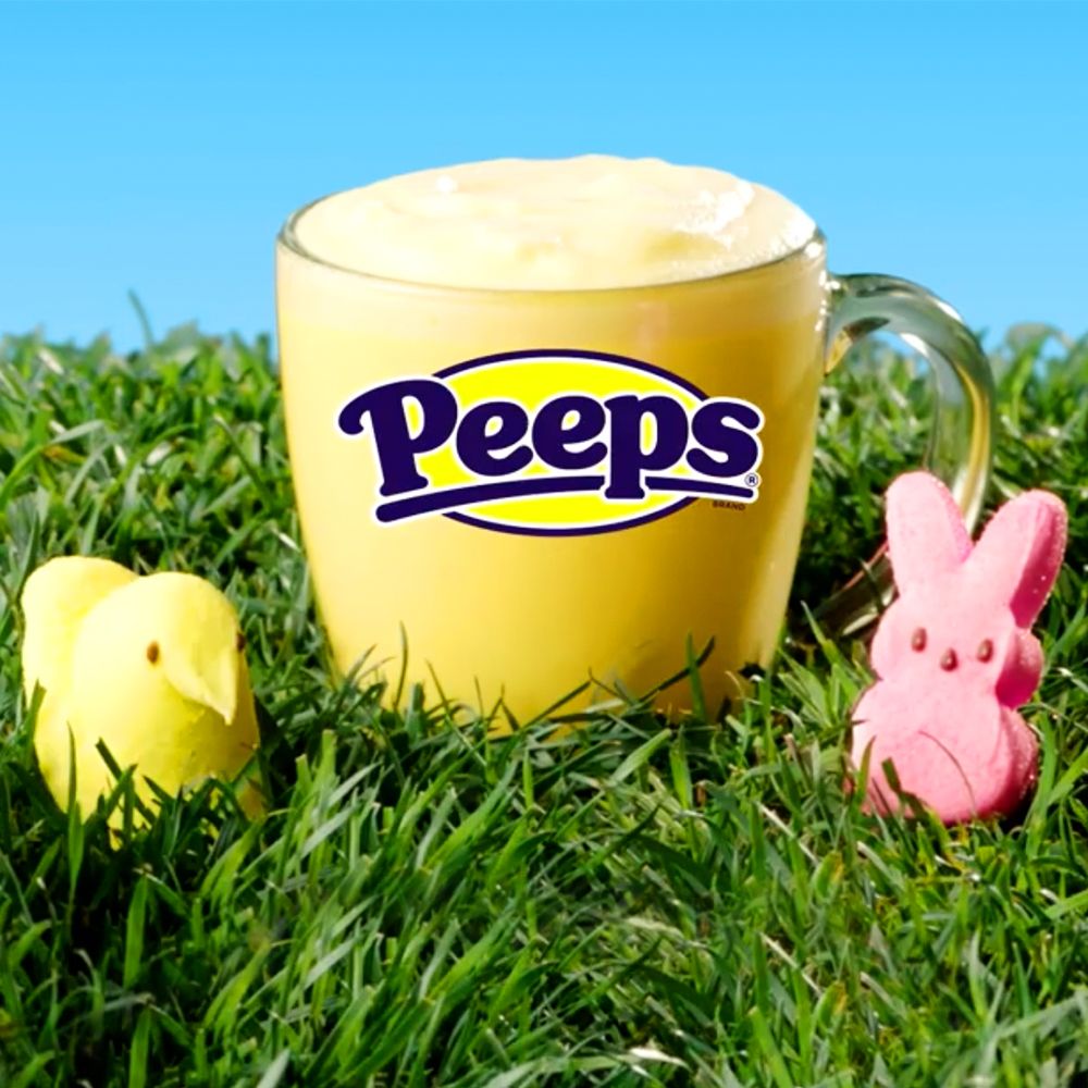 yellow peeps latte from 7 eleven sitting in grass surrounded by peeps