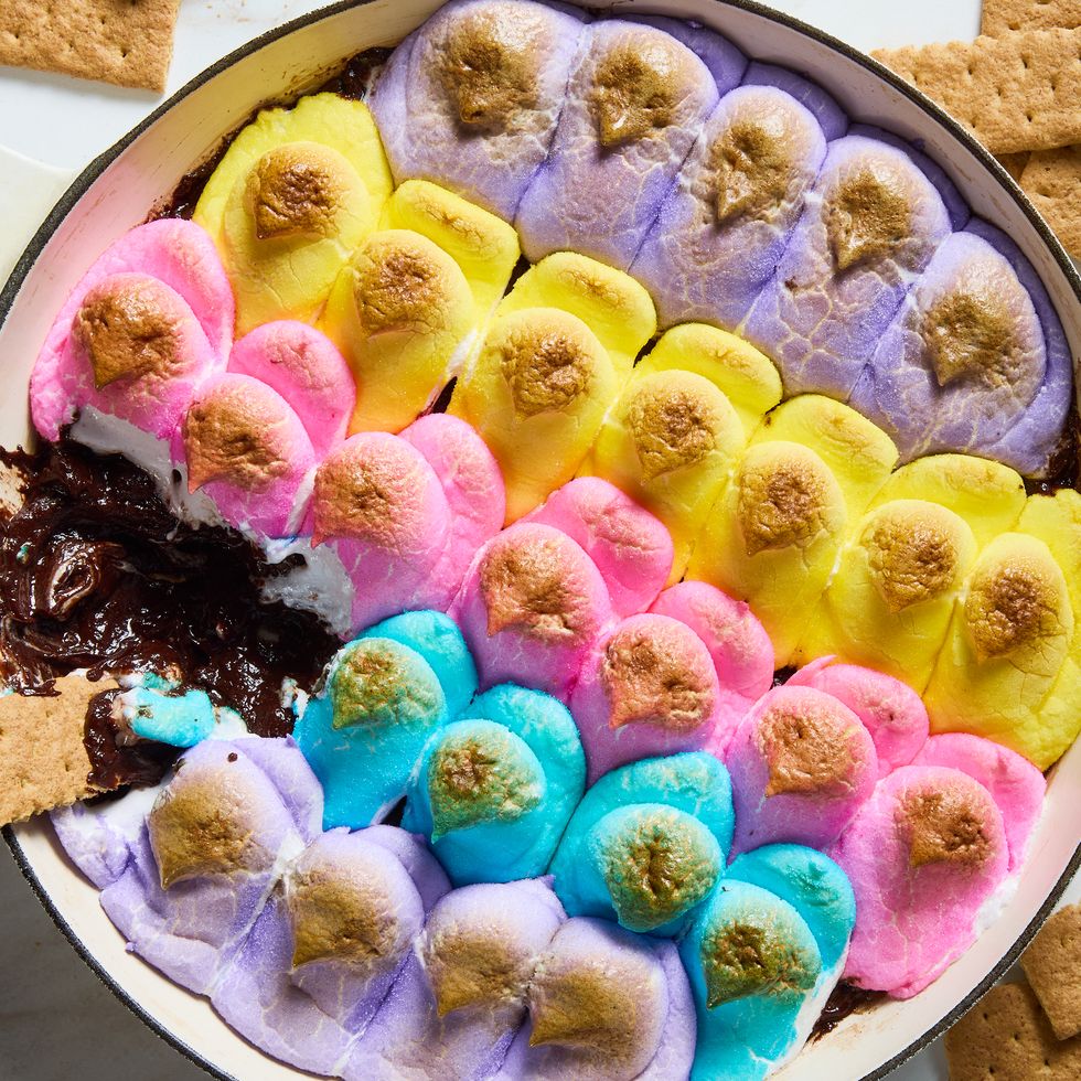 baked chocolate topped with multicolored peeps in a skillet served with graham crackers