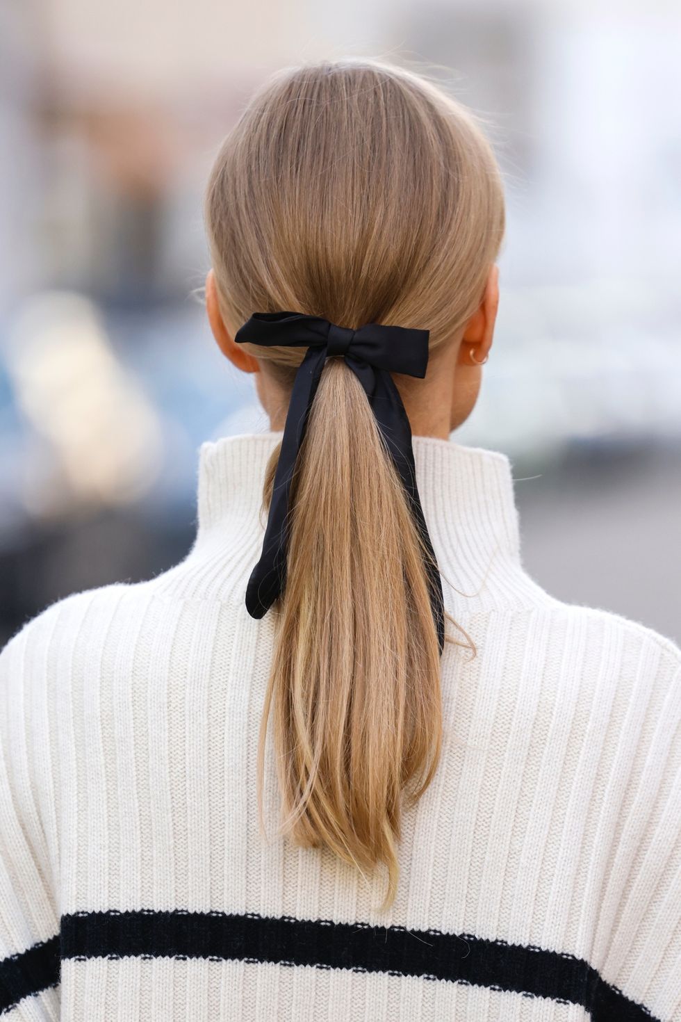munich, germany   january 27 influencer and model marlies pia pfeifhofer wearing a white knitted turtleneck pullover with black stripes by hm, symbol sunglasses by prada and a black hair tie with bow during a street style shooting on january 27, 2022 in munich, germany photo by streetstyleshootersgetty images