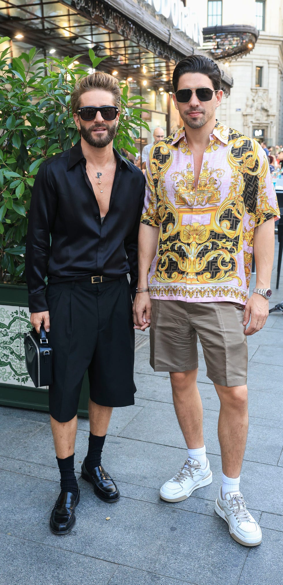 pelayo diaz, de negro, y su novio ga marom, con bermudas y camisa estampada, a su llegada a su fiesta de cumpleanos