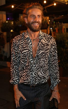 pelayo diaz con una camisa de estampado de cebra y pantalon negro a su salida de un restaurante en madrid