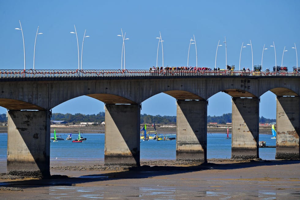 los ciclistas del tour de francia atraviesan un puente camino de la isla de re