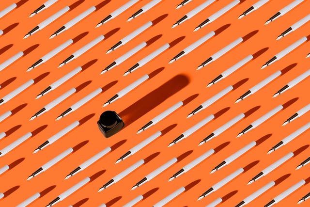 pen and ink pattern on vibrant orange colored background high angle view