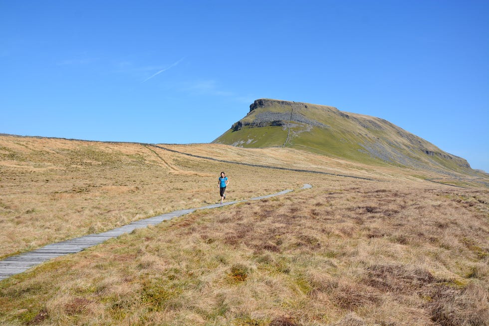 a woman running on a path near pen y ghent