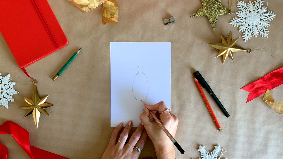 a person drawing a penguin with a pencil on a piece of paper