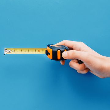 diy concepthand holding tape measure on blue background