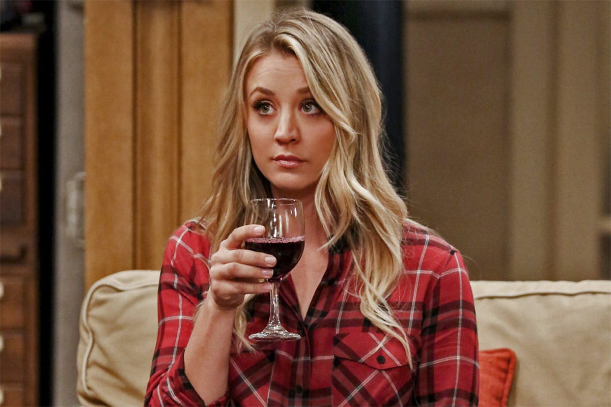 kaleycuoco, penny en 'the big bang theory' con una copa de vino tinto