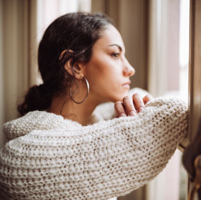 pensive woman in front of the window